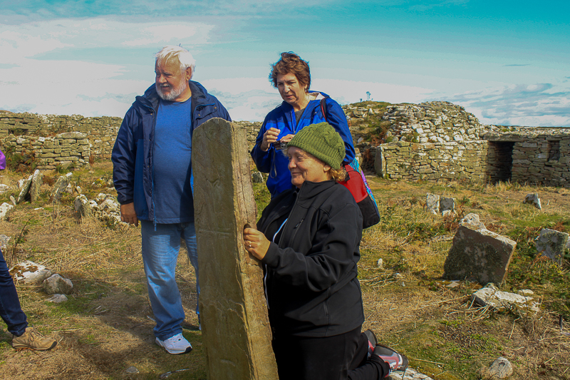 Guests on Discover the North 2013 tour on Inishmurray at the fertility stone. 